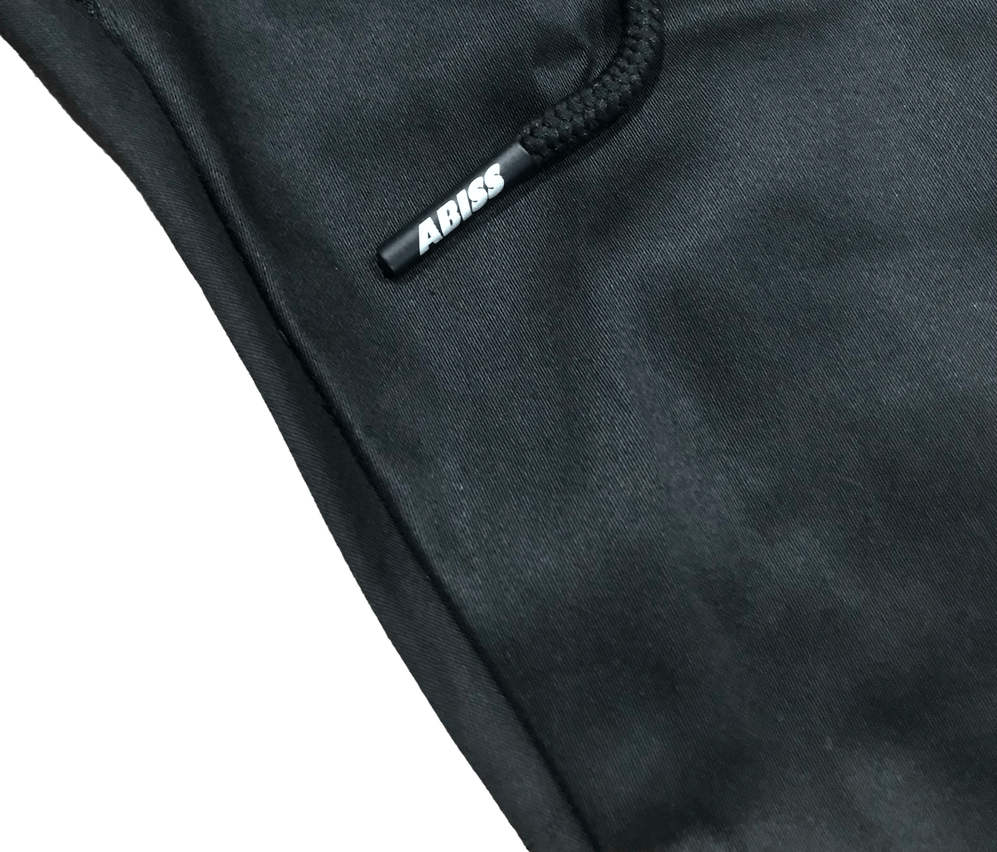 Close-up of C2-K1 pants showing Abiss Apparel custom printed aglet, part of unique streetwear collection.